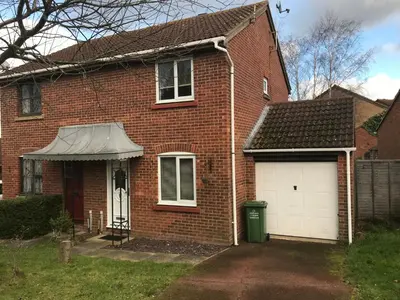 a red brick house with a white garage at Comfortable Billericay Home in Billericay
