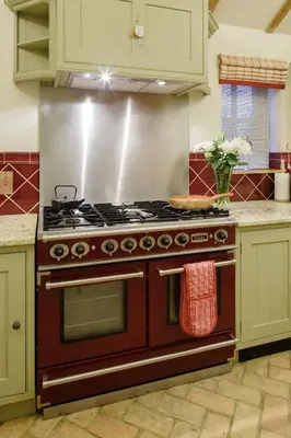 a kitchen with a red stove top oven in a kitchen at Lavender Cottage in Thorndon