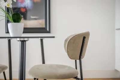 a chair and a table with a potted plant at Luxury Parkway Apartment in Chelmsford City in Chelmsford
