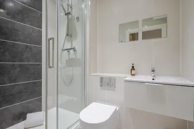 a bathroom with a shower and a toilet and a sink at Luxury Parkway Apartment in Chelmsford City in Chelmsford