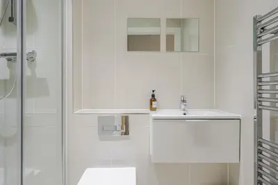 a white bathroom with a sink and a shower at Luxury Parkway Apartment in Chelmsford City in Chelmsford