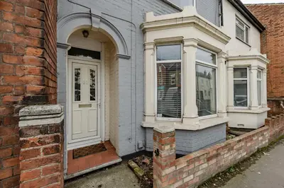 a home with a white door and a brick wall at The White Rose Crown, Free Parking & Wifi, 10beds in Colchester