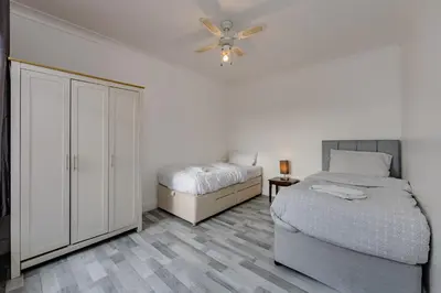 a bedroom with two beds and a ceiling fan at The White Rose Crown, Free Parking & Wifi, 10beds in Colchester