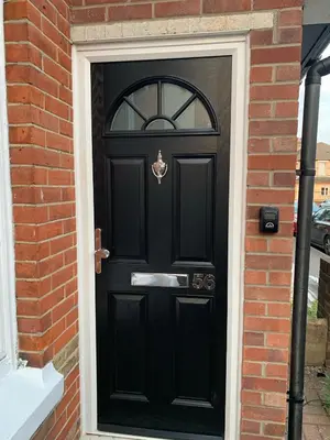 a black front door of a brick house at The Velveteen Townhouse in Colchester