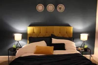 a bedroom with a king sized bed with two lamps at The Velveteen Townhouse in Colchester