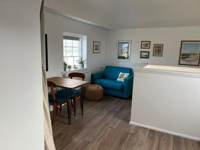 a living room with a blue couch and a table at Loft in Bungay in Bungay