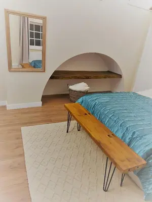 a bedroom with a bed and a mirror and a bench at Loft in Bungay in Bungay