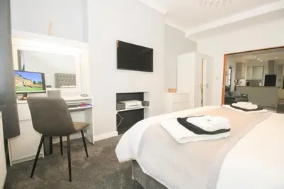 a bedroom with a bed and a desk and a television at Roman Quarter in Colchester