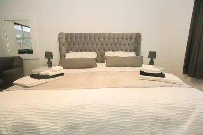 a large bed with a large headboard in a bedroom at Roman Quarter in Colchester