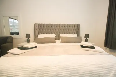 a bedroom with a large bed with a large headboard at Roman Quarter in Colchester