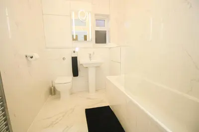 a white bathroom with a toilet and a sink at Roman Quarter in Colchester
