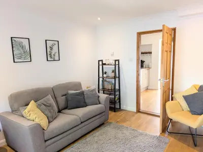 a living room with a couch and a mirror at The Retreat on Risbygate in Bury Saint Edmunds