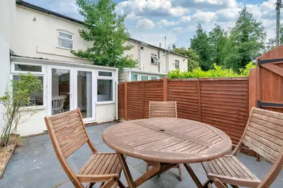 a patio with a wooden table and two chairs at The Retreat on Risbygate in Bury Saint Edmunds