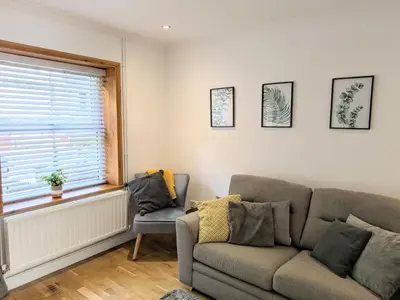 a living room with a couch and a window at The Retreat on Risbygate in Bury Saint Edmunds