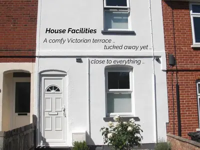 a white house with a sign on the side of it at Victorian Terrace Old Stoke - With Self Check In and Free Parking - Rooms at ipswichdigs in Ipswich