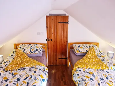 a bedroom with two beds and a wooden cabinet at Hikers & Bikers Refuge in Ipswich