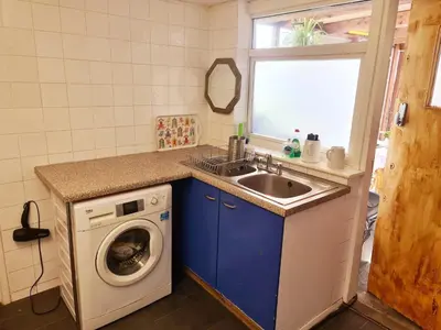 a kitchen with a sink and a washing machine at Hikers & Bikers Refuge in Ipswich