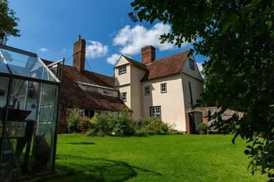 a large white house with a grass yard at Pounce Hall -Stunning historic home in rural Essex in Saffron Walden