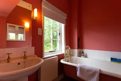 a bathroom with a sink and a tub and a window at Pounce Hall -Stunning historic home in rural Essex in Saffron Walden