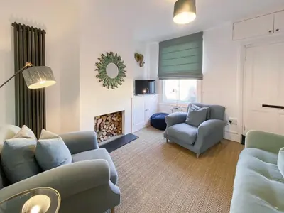 a living room with blue chairs and a fire place at 3 Chestnut Terrace by The Suffolk Cottage Collection in Long Melford