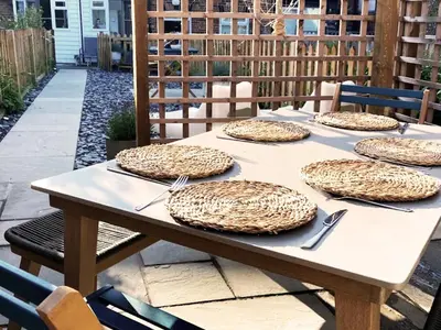 a wooden table with four plates on it at 3 Chestnut Terrace by The Suffolk Cottage Collection in Long Melford