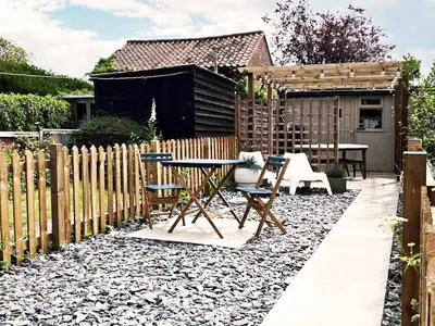 a garden with a table and chairs and a fence at 3 Chestnut Terrace by The Suffolk Cottage Collection in Long Melford