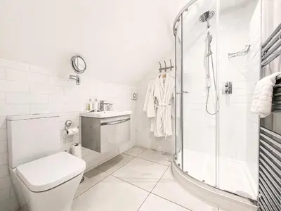 a white bathroom with a shower and a toilet at 3 Chestnut Terrace by The Suffolk Cottage Collection in Long Melford