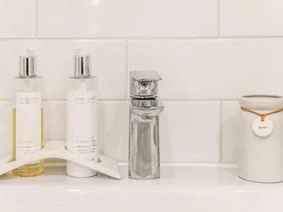 a group of bottles sitting on a bathroom counter at 3 Chestnut Terrace by The Suffolk Cottage Collection in Long Melford