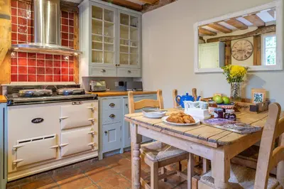 a kitchen with a table with a plate of food on it at Extraordinary 15th Century timber framed cottage in famous Medieval village - The Tryst in Lavenham