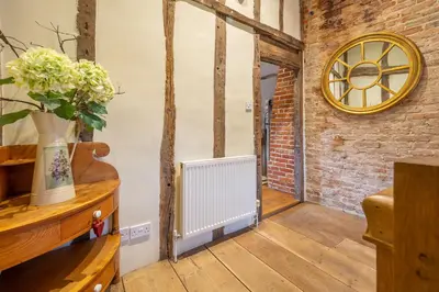 a room with a radiator and a brick wall at Extraordinary 15th Century timber framed cottage in famous Medieval village - The Tryst in Lavenham