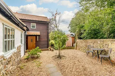 a small garden with a table and chairs in front of a house at 2 Bed in Snape oc-wico in Snape