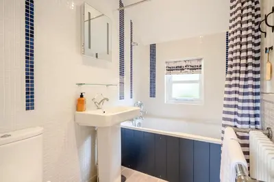 a white bathroom with a sink and a bath tub at 2 Bed in Snape oc-wico in Snape