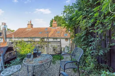 a patio with tables and chairs in a garden at 1 Bed in Woodbridge oc-11ang in Woodbridge