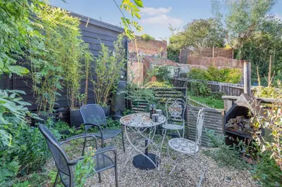 a garden with a table and chairs and a fire place at 1 Bed in Woodbridge oc-11ang in Woodbridge