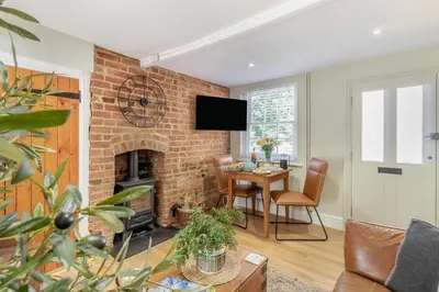 a living room with a brick fireplace and a table at 1 Bed in Woodbridge oc-11ang in Woodbridge