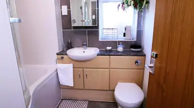 a bathroom with a sink and a toilet and a mirror at FREE parking, Central Location,1 Bedroom Apartment near Tattersalls in Newmarket
