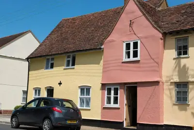 a car parked in front of a colorful house at Meddlars a historic cottage on the countryside edge of a vibrant Market Town in Hadleigh