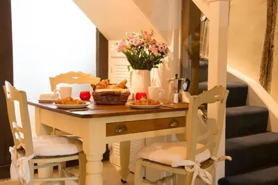 a dining room table with food and flowers on it at Meddlars a historic cottage on the countryside edge of a vibrant Market Town in Hadleigh