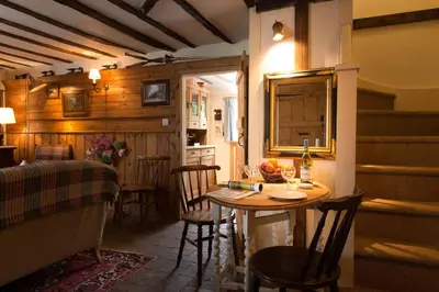 a kitchen with a table and chairs in a room at Spadgers, a flax workers cottage next to fields in a Medieval Village in Long Melford