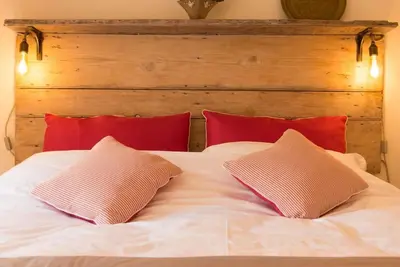 a white bed with two pillows on top of it at Romney, a cosy Victorian cottage in a picturesque Suffolk village in Cavendish