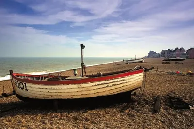a boat sitting on the shore of a beach at Queenies, an authentic Rural Style coastal cottage in a Nature Reserve in Farnham