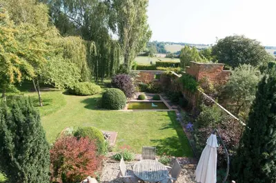 an overhead view of a garden with a table and an umbrella at The Old Steam Mill, luxury, spacious, beautiful grounds, stunning location in Hartest