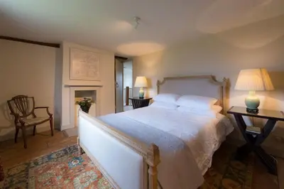 a bedroom with a large bed and a table and lamp at Navigation Cottage on the Historic Sea Lock overlooking the Nature Reserve in Maldon