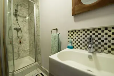 a bathroom with a shower and a sink and a tub at The Old Monkey, a quirky bolthole on the edge of a historic Market Town in Hadleigh