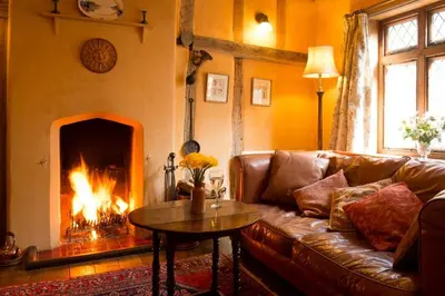 a living room with a couch and a fireplace at The Old Monkey, a quirky bolthole on the edge of a historic Market Town in Hadleigh