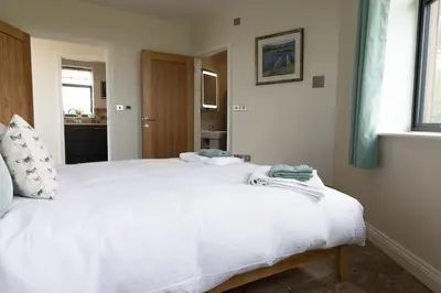 a bedroom with a large white bed in it at The Hexagon, wow what a location, views over the Essex marshes and sea in West Mersea