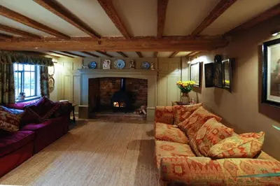 a living room with a couch and a fireplace at Laundry Cottage in a Nature Reserve - Sunday Times 100 coolest Cottages in Farnham