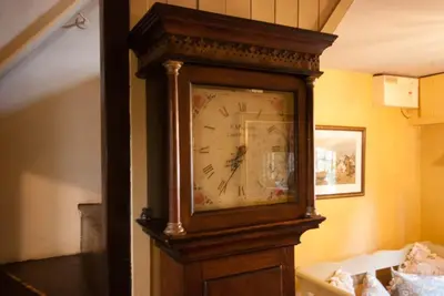 a grandfather clock is sitting in a room at Cissys Cottage in a Nature Reserve, 7 minutes from Aldeburgh seafront in Farnham
