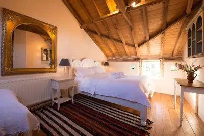 a bedroom with two beds and a mirror at Orchard Cottage cosy rustic comfort just across the fields to a great Pub in Edwardstone
