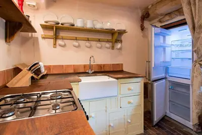 a kitchen with a sink and a stove at Orchard Cottage cosy rustic comfort just across the fields to a great Pub in Edwardstone